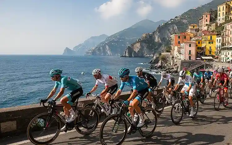 Wielrenners langs Italiaanse kust tijdens Milaan-San Remo