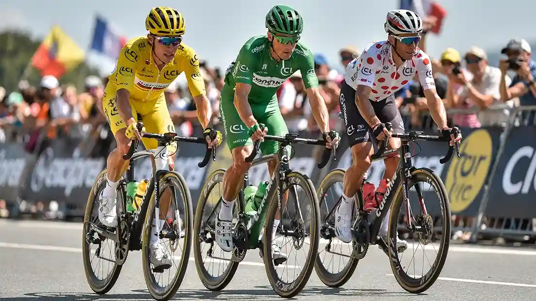 Drie wielrenners in gele, groene en bolletjestrui tijdens Tour de France etappe