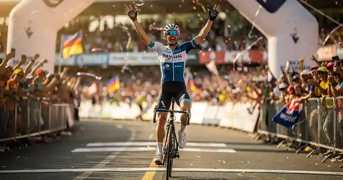 Wielrenner steekt armen omhoog bij finish als winnaar